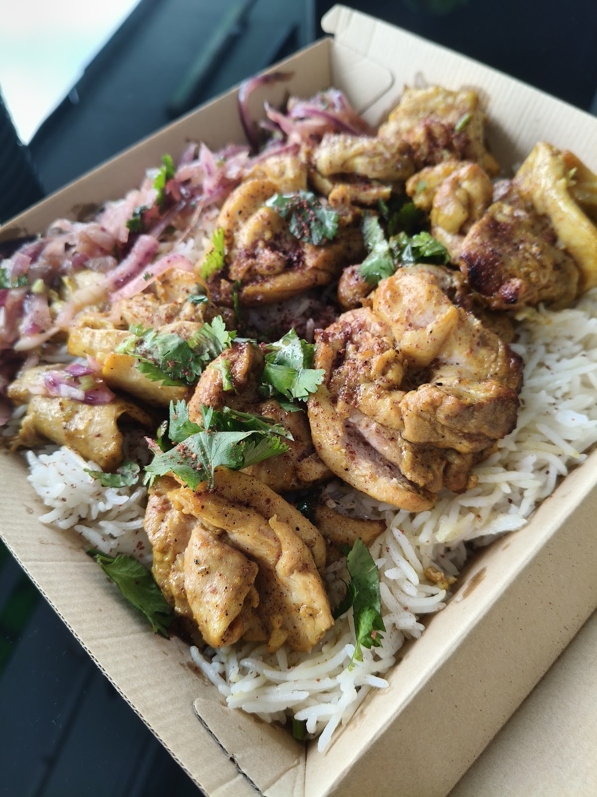 Chicken boti takeaway box with rice and pickled onion slaw